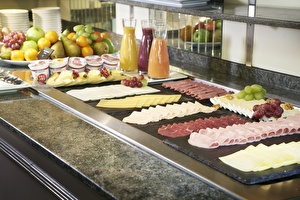 Amrâth Hotel Lapershoek Arenapark Restaurant Vivaldi Frühstücksbuffet, Platte mit Aufschnitt, Käse, Wurst und Brie, Platte mit Obst, Äpfeln, Trauben, Säften und Joghurt.