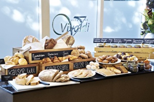 Amrâth Hotel Lapershoek Arenapark Restaurant Vivaldi Frühstücksbuffet mit Brötchen und verschiedenen Aufstrichen.