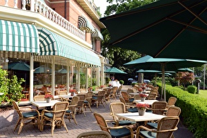 Amrâth Hotel Lapershoek Arenapark Terrasse angrenzend an das Restaurant Vivaldi. Sonnenschirme sind über den Tischen und Stühlen auf der Terrasse ausgeklappt.