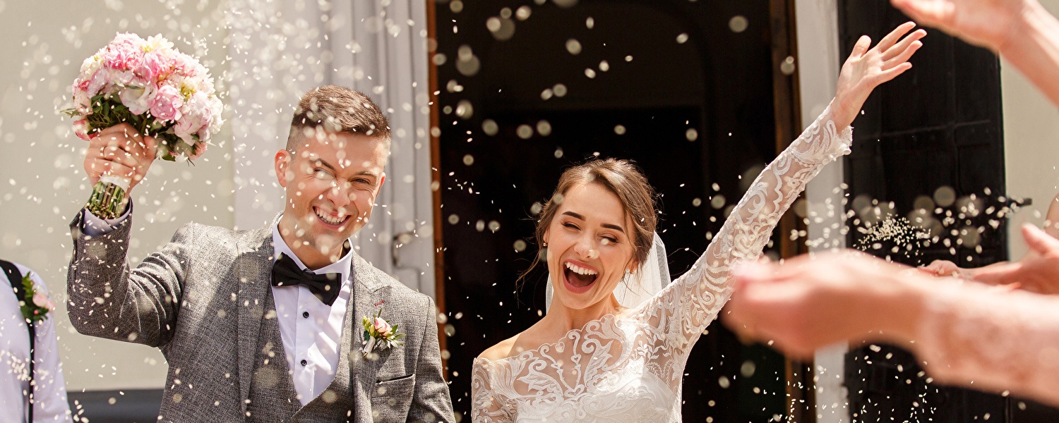 Een pasgetrouwd stel wordt bedekt met confetti tijdens hun feestelijke viering.