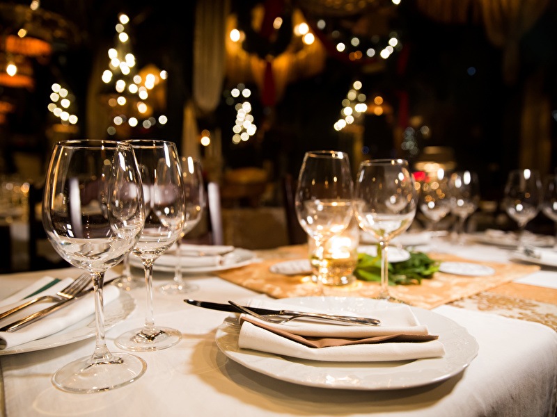 Mooie sfeervolle opgedekte tafel, met glazen en witte borden klaar voor een heerlijk diner